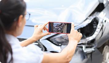 a woman taking a picture of a man in a car