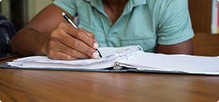 a person writing on a piece of paper