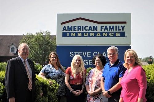 a group of people posing for a photo in front of a sign