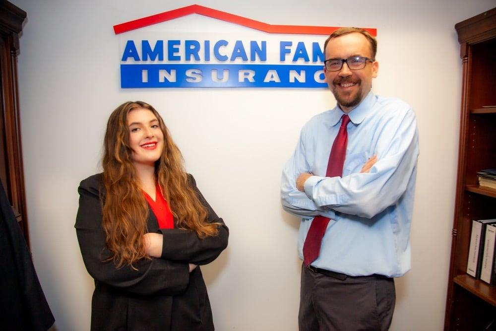 a man and a woman standing in front of a sign