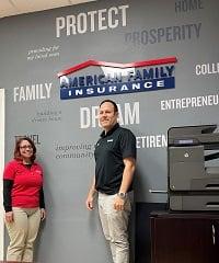 a man and a woman standing in front of a sign