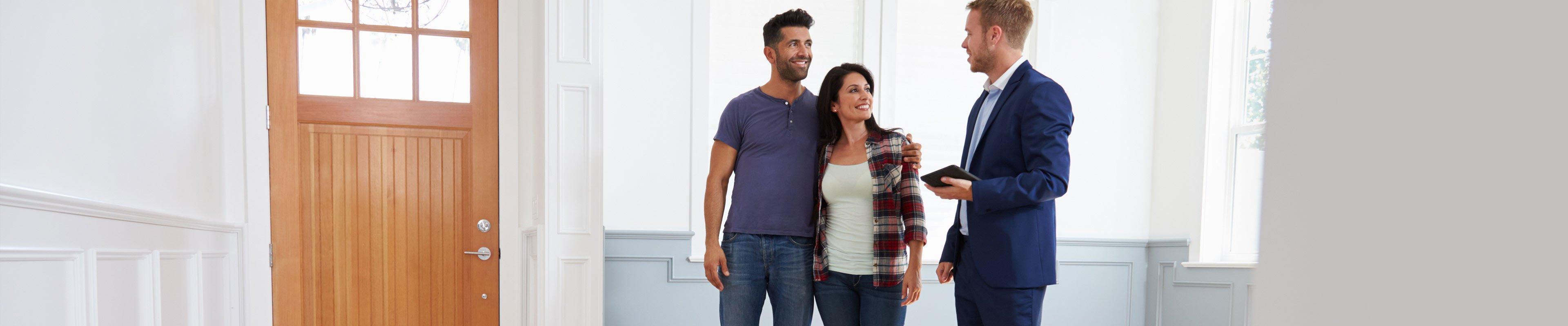 Realtor and young couple going through the home buying steps.