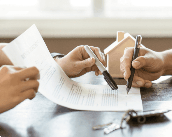 Person reviewing a document with someone across a desk. 