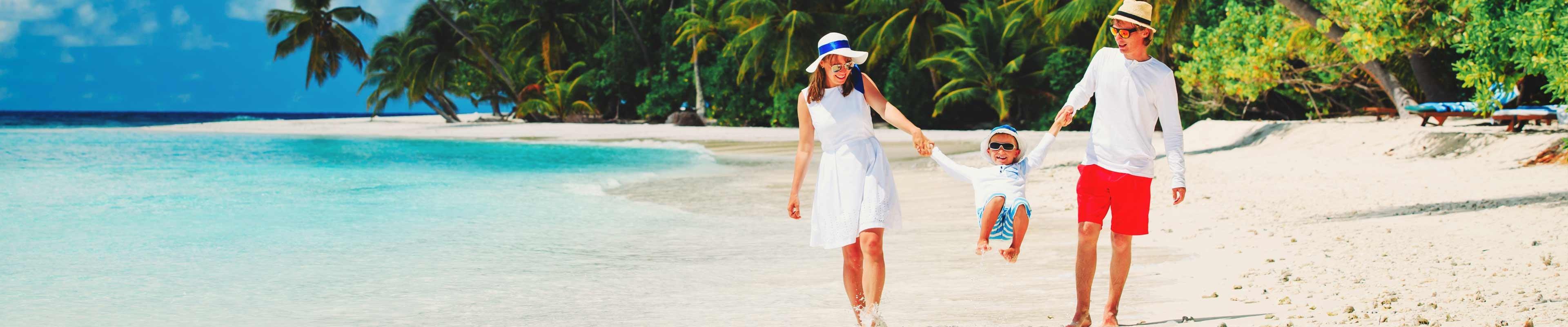 family walking hand in hand down beautiful beach while on their ultimate dream vacation. 