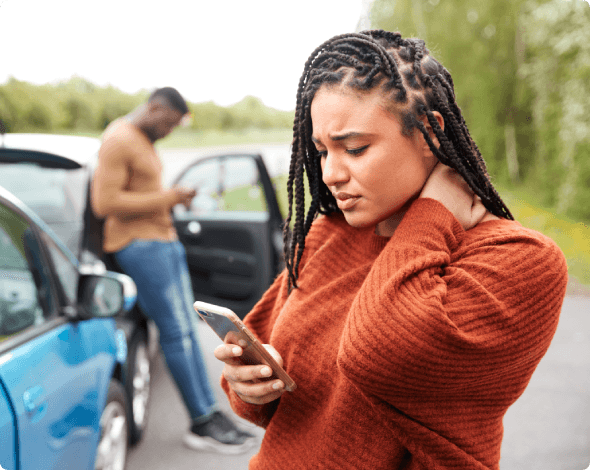 Woman looking stressed and looking at her phone after an accident