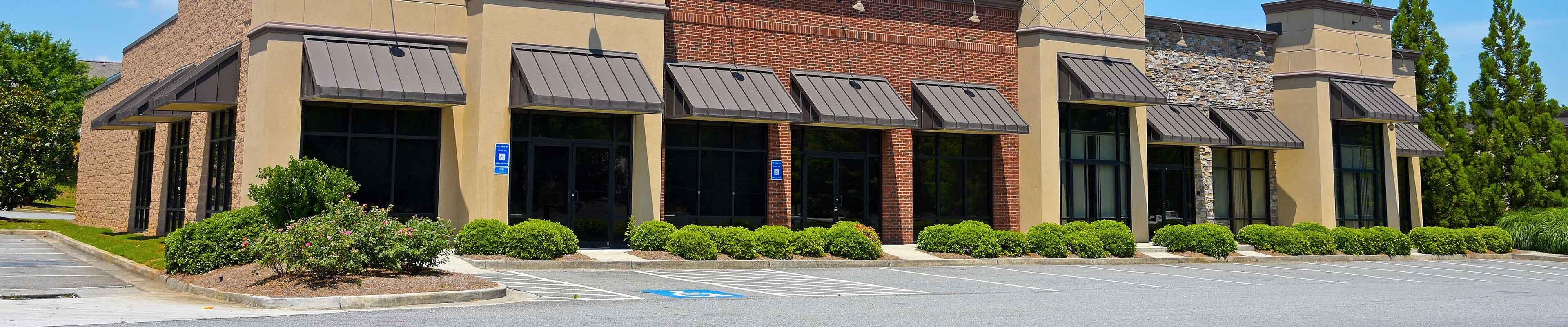 Image of a vacant commercial strip mall property and parking lot.