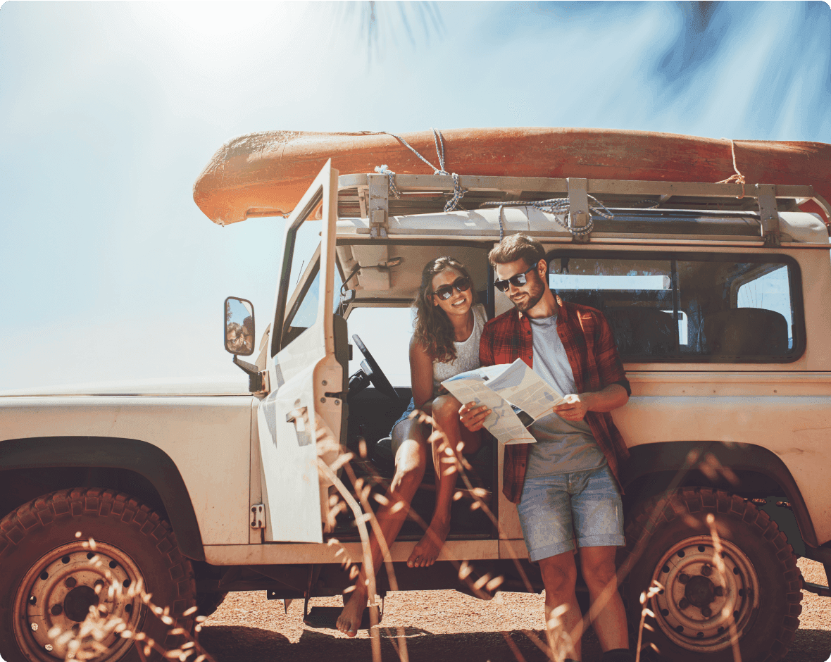 a man and woman standing in a jeep